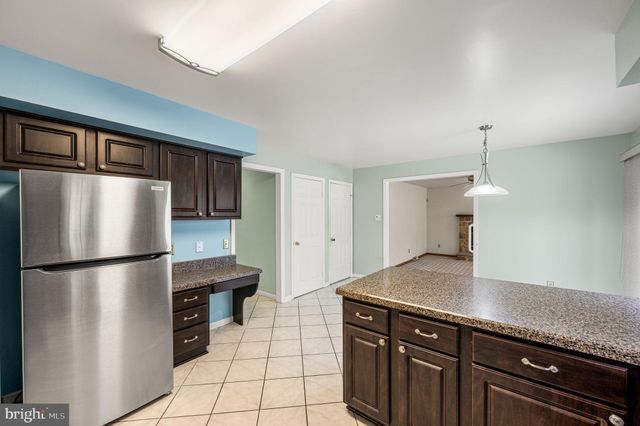 a kitchen with stainless steel appliances granite countertop a refrigerator a sink and white cabinets