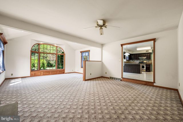 a view of an empty room with a window and bathroom