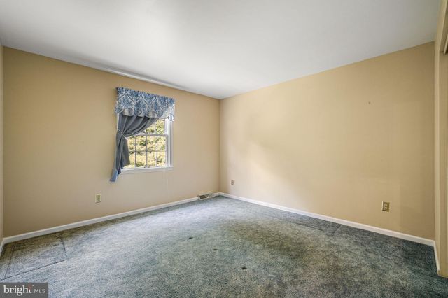 a bathroom with a granite countertop sink toilet a mirror and a window