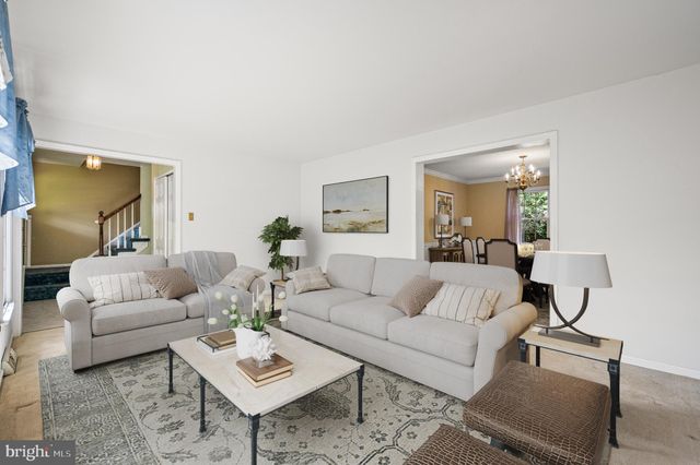 a living room with furniture a rug and a lamp