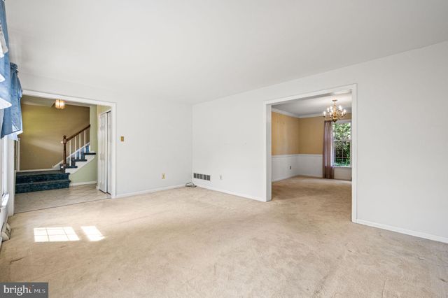 a view of an empty room and a kitchen