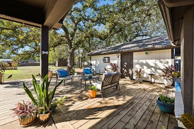 a view of a patio with table and chairs potted plants and floor to ceiling window