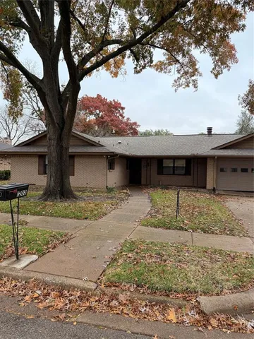 a view of a house with a tree tree in front of it