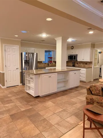 a kitchen with stainless steel appliances granite countertop a stove top oven a sink dishwasher and a refrigerator