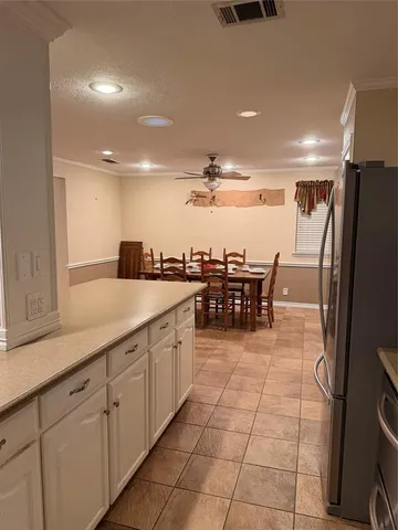 a large kitchen with stainless steel appliances a sink and cabinets