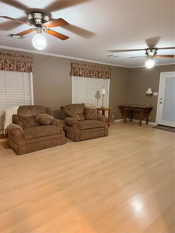 a living room with furniture gym equipment and a ceiling fan