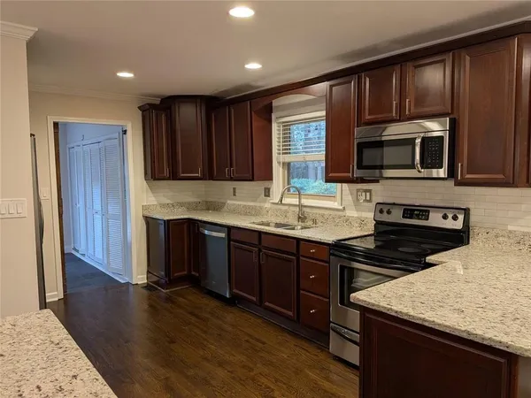a kitchen with a stove a sink and a microwave