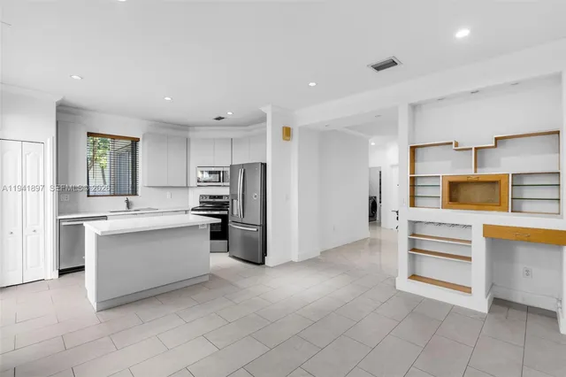 a kitchen with stainless steel appliances a refrigerator and a stove top oven