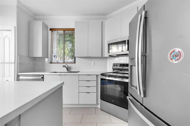 a kitchen with cabinets appliances and a window