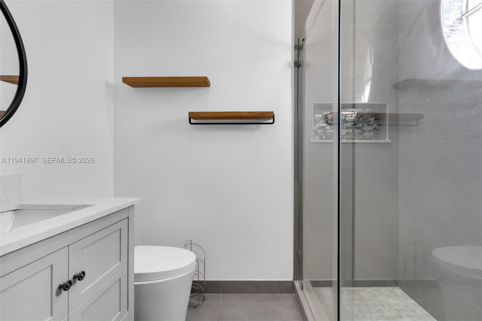 5505 Northwest 112th Path, Unit 5505 Doral, FL 33178 - Photo 24 of 44 a bathroom with a toilet a sink and a mirror