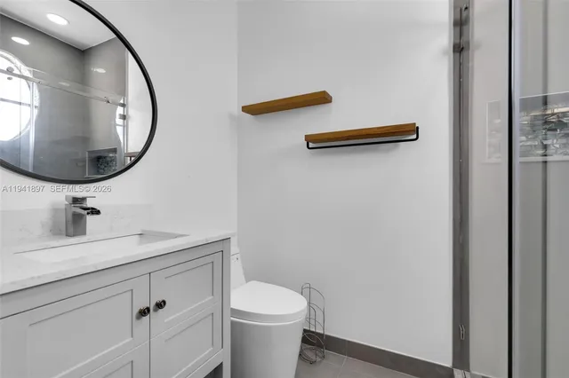 a bathroom with a granite countertop sink and a mirror