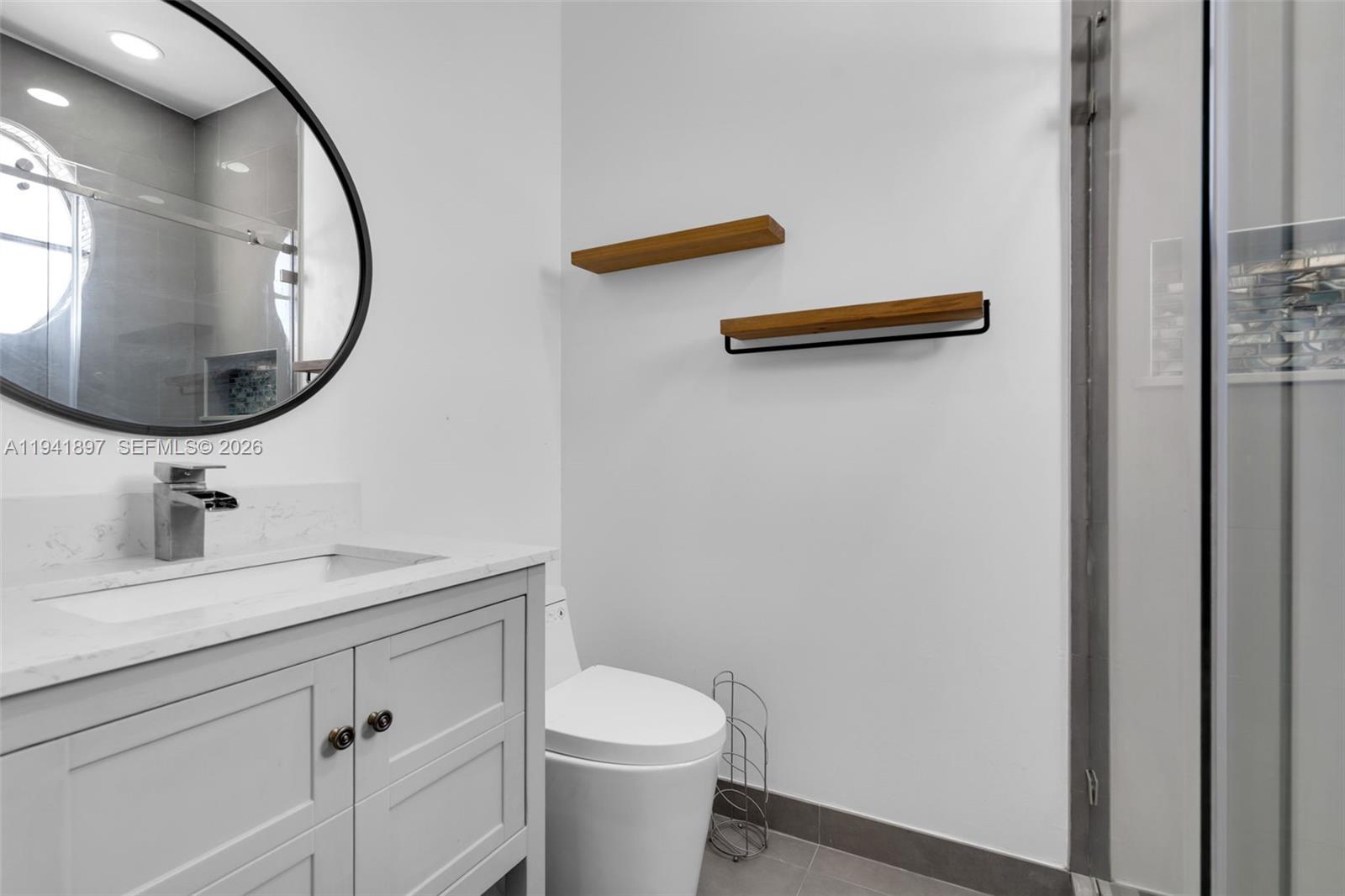 5505 Northwest 112th Path, Unit 5505 Doral, FL 33178 - Photo 25 of 44 a bathroom with a granite countertop sink and a mirror