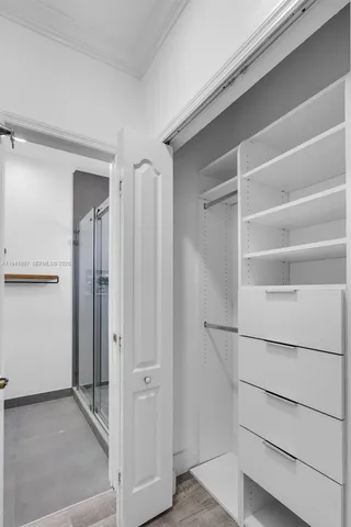 a view of walk in closet with empty racks