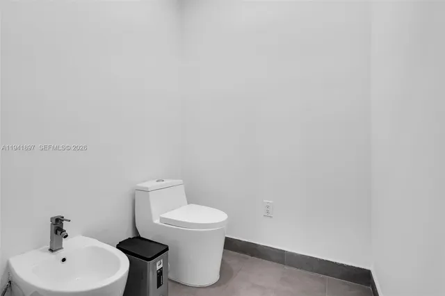 a white toilet sitting next to a white sink