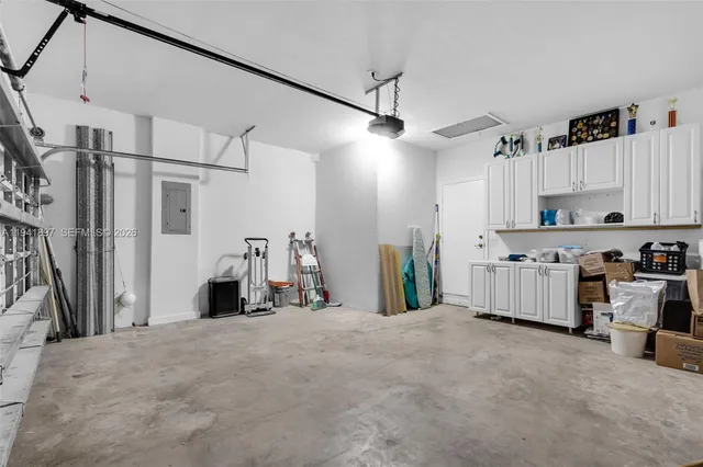 a kitchen with stainless steel appliances kitchen island a refrigerator sink and white cabinets