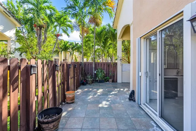 a view of a backyard with wooden fence and a potted plant