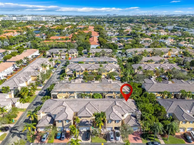 an aerial view of residential houses with outdoor space and swimming pool