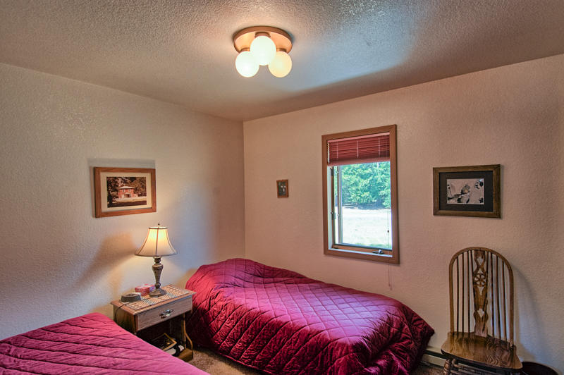 9375 Thatcher Mill Road Shingletown, CA 96088 - Photo 10 of 23 a bedroom with a bed and a window