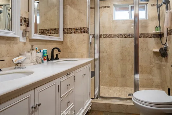 a bathroom with a shower sink vanity mirror and toilet