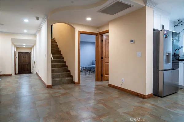 a view of a hallway with entryway and stairs