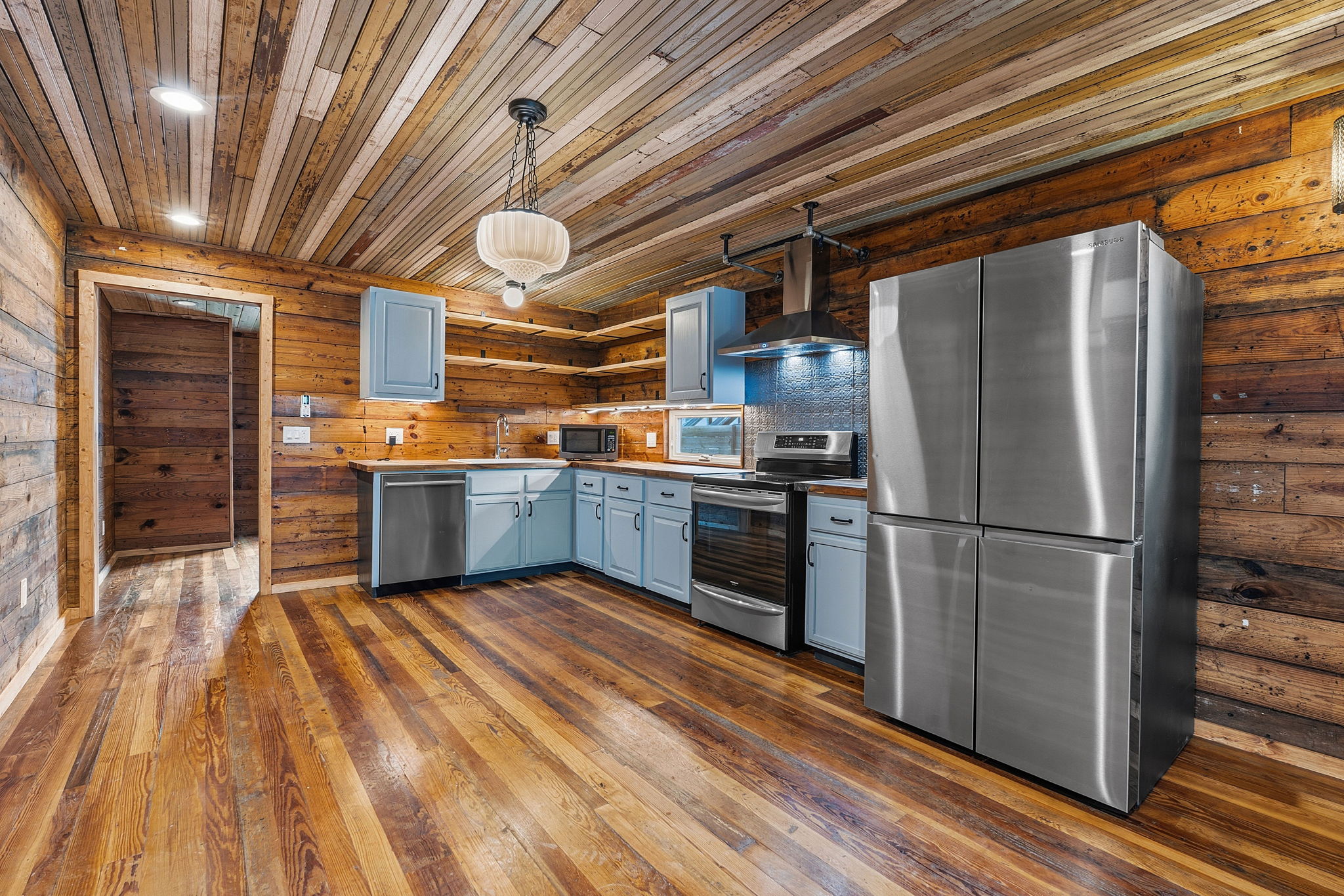 1148 Gunter Street Austin, TX 78721 - Photo 6 of 18 a kitchen with stainless steel appliances granite countertop a refrigerator a sink and wooden floors