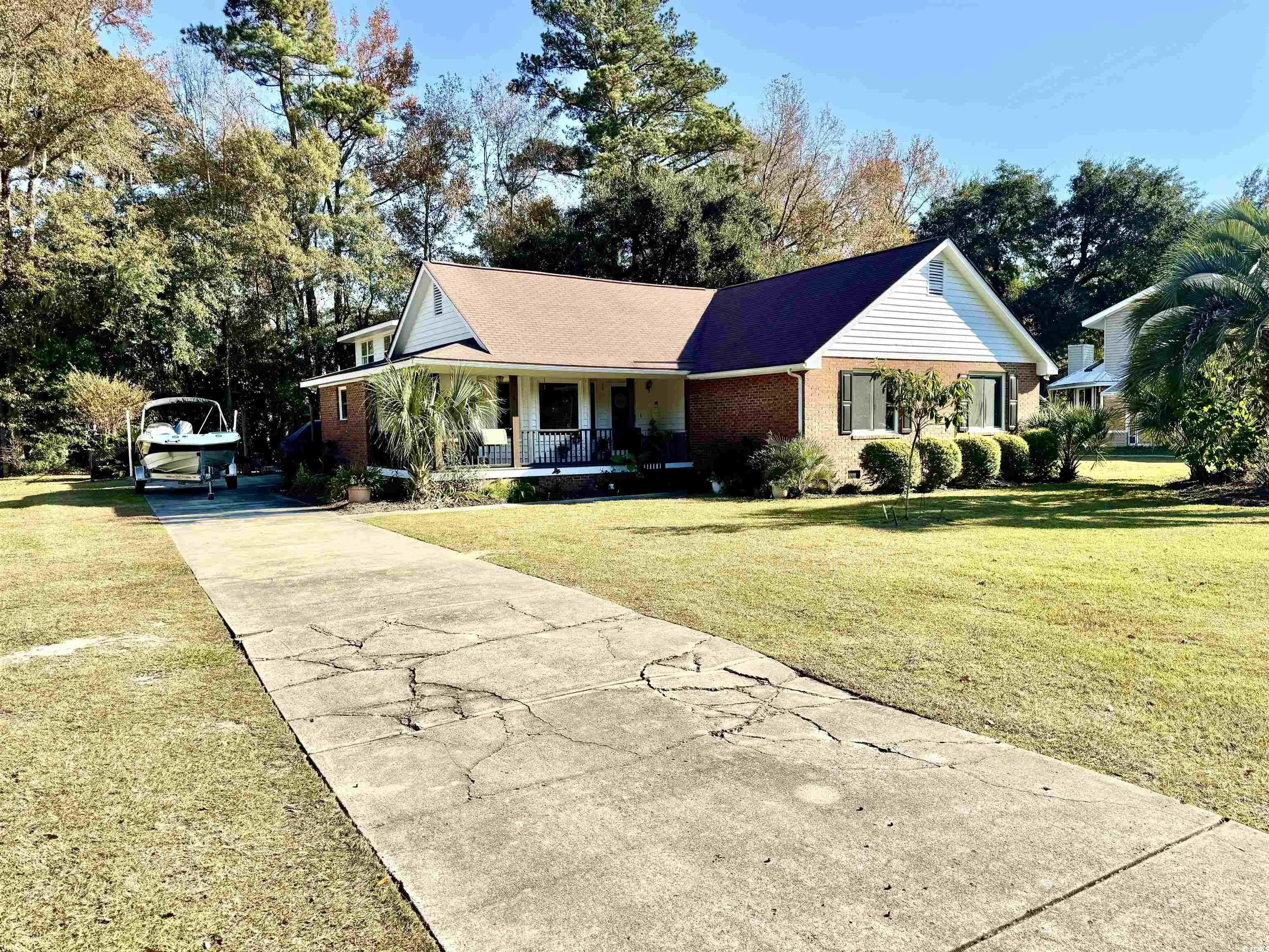 40 Governor Boone Lane Georgetown, SC 29440 - Photo 19 of 33 View of front of house featuring a porch, brick siding, a front lawn, and concrete driveway