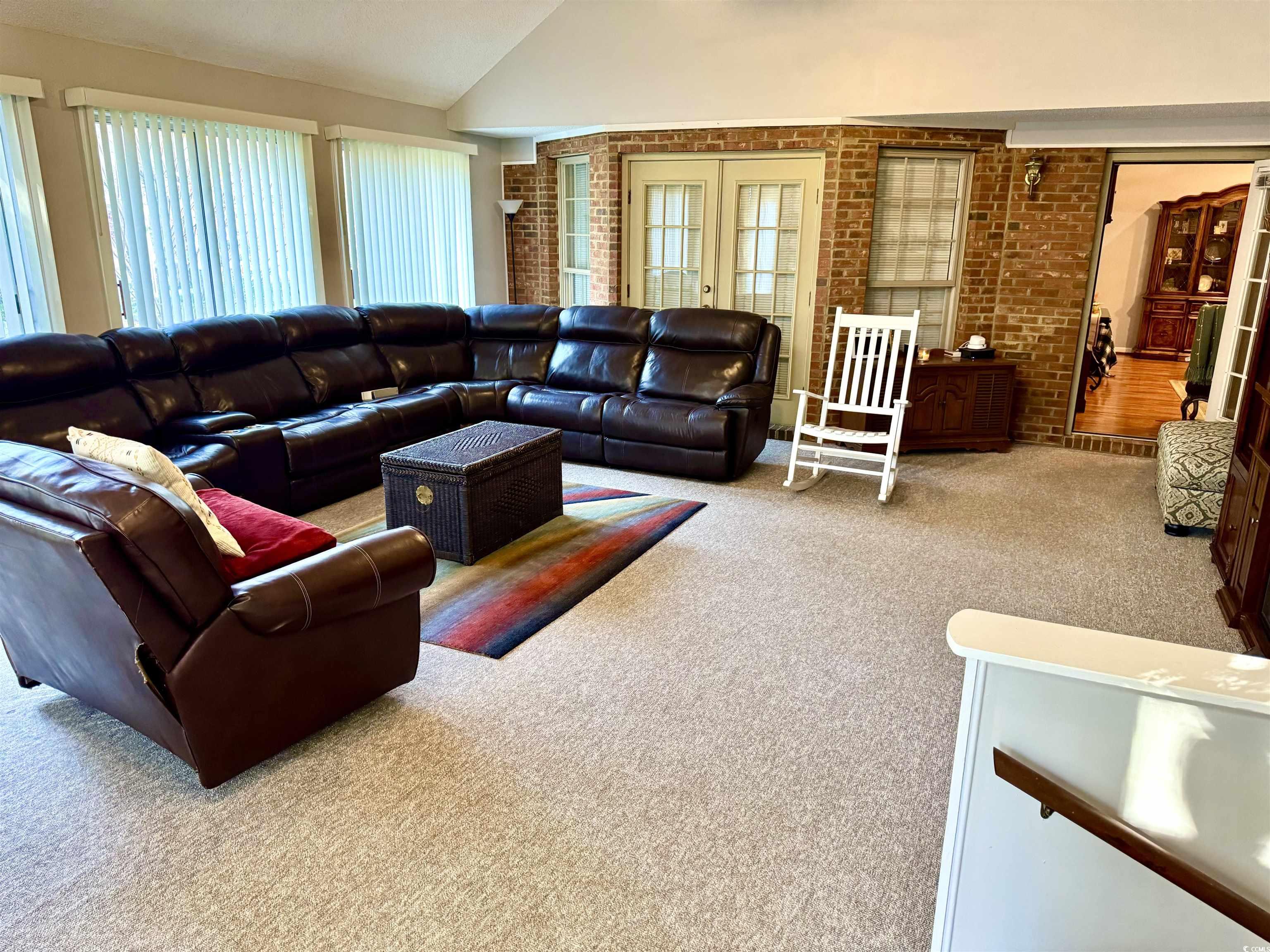 40 Governor Boone Lane Georgetown, SC 29440 - Photo 3 of 33 Living room featuring carpet, plenty of natural light, brick wall, lofted ceiling, and french doors