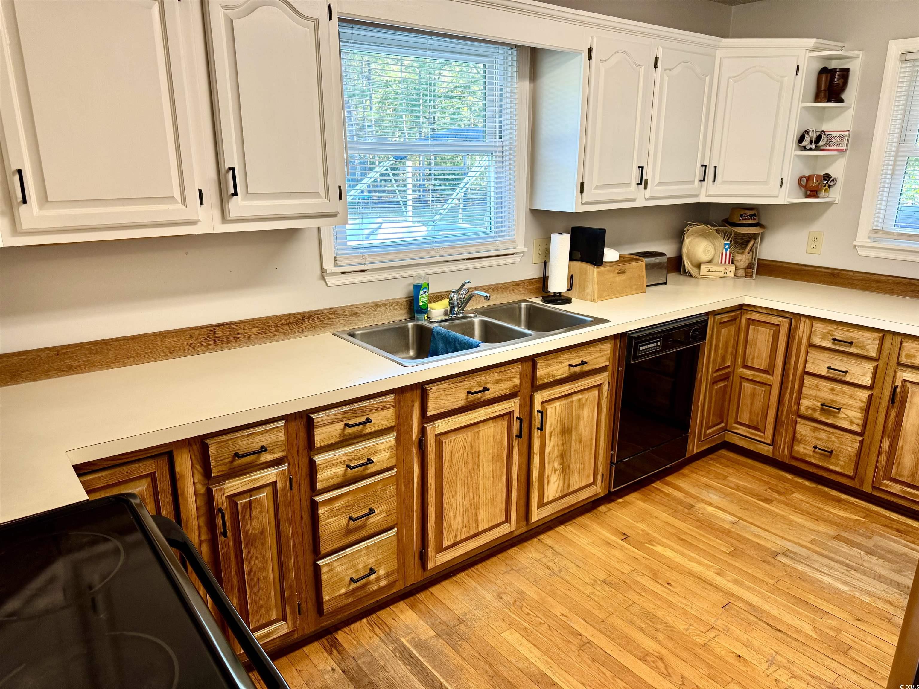 40 Governor Boone Lane Georgetown, SC 29440 - Photo 7 of 33 Kitchen featuring light countertops, black appliances, light wood finished floors, and open shelves