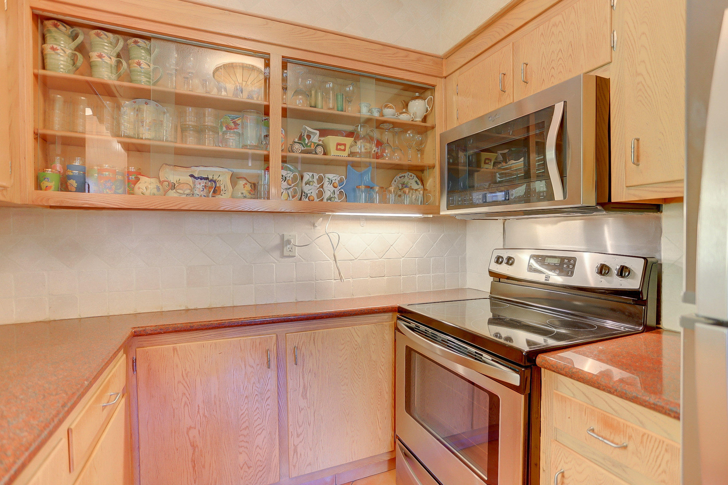 6520 North Ocean Boulevard, Unit 28 Ocean Ridge, FL 33435 - Photo 18 of 32 a kitchen with stainless steel appliances granite countertop a stove and a microwave
