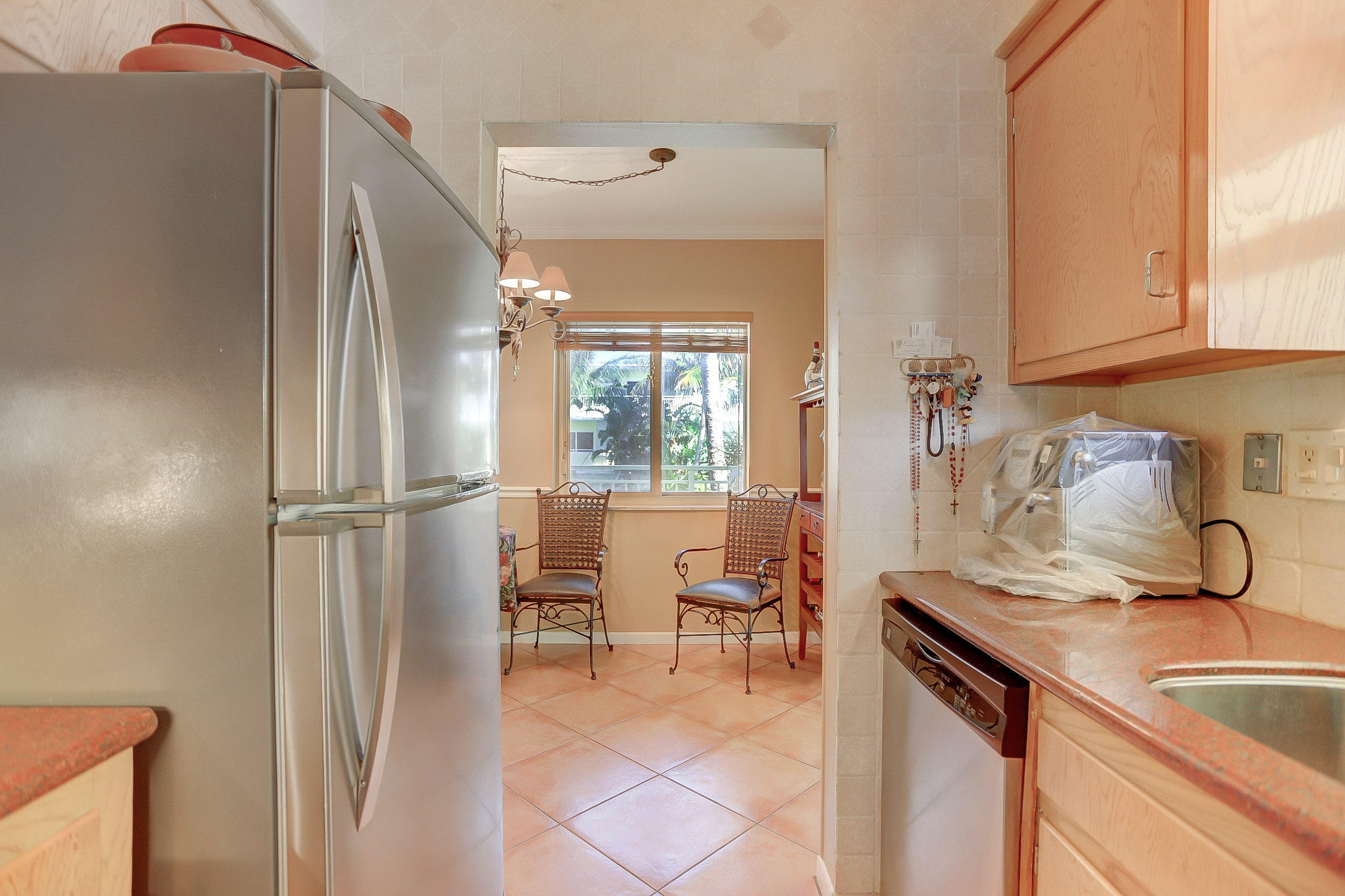 6520 North Ocean Boulevard, Unit 28 Ocean Ridge, FL 33435 - Photo 19 of 32 a kitchen with stainless steel appliances granite countertop a refrigerator and a sink
