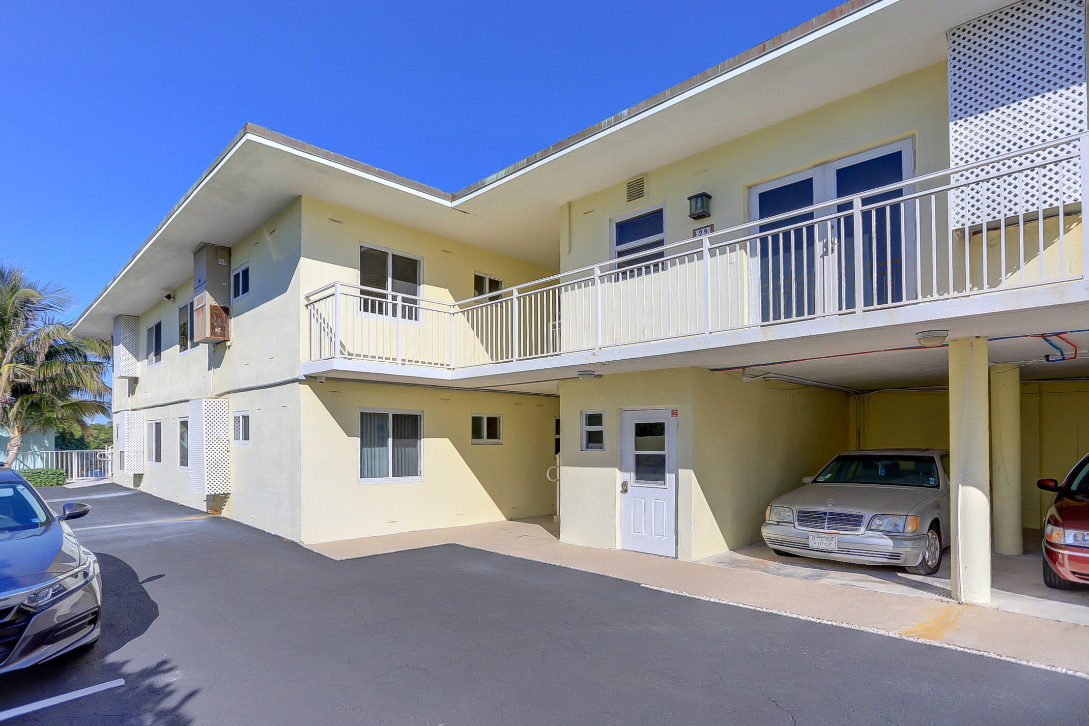 6520 North Ocean Boulevard, Unit 28 Ocean Ridge, FL 33435 - Photo 2 of 32 a view of a white house with many windows