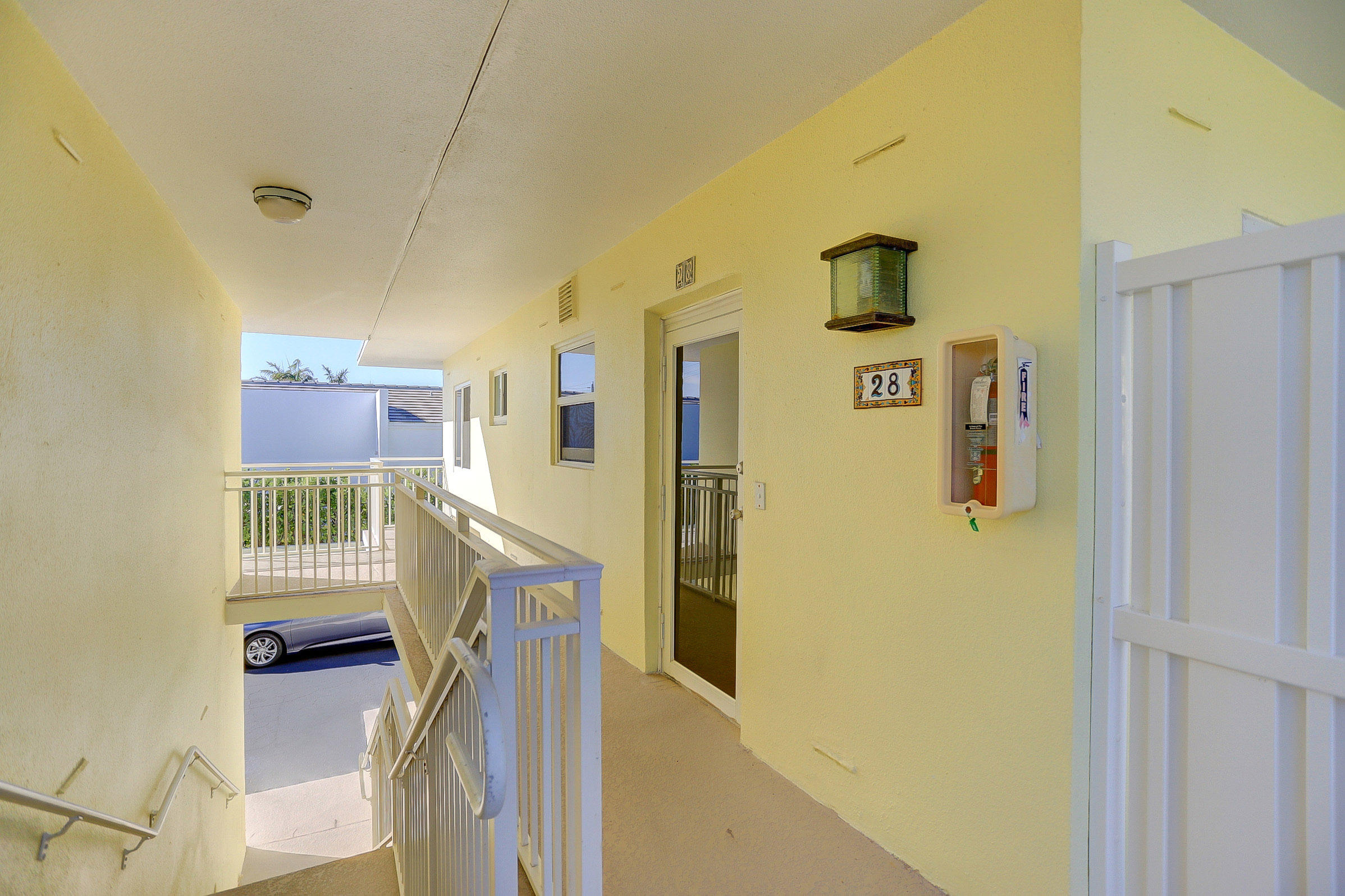 6520 North Ocean Boulevard, Unit 28 Ocean Ridge, FL 33435 - Photo 4 of 32 a view of a hallway with entryway wooden floor and front door