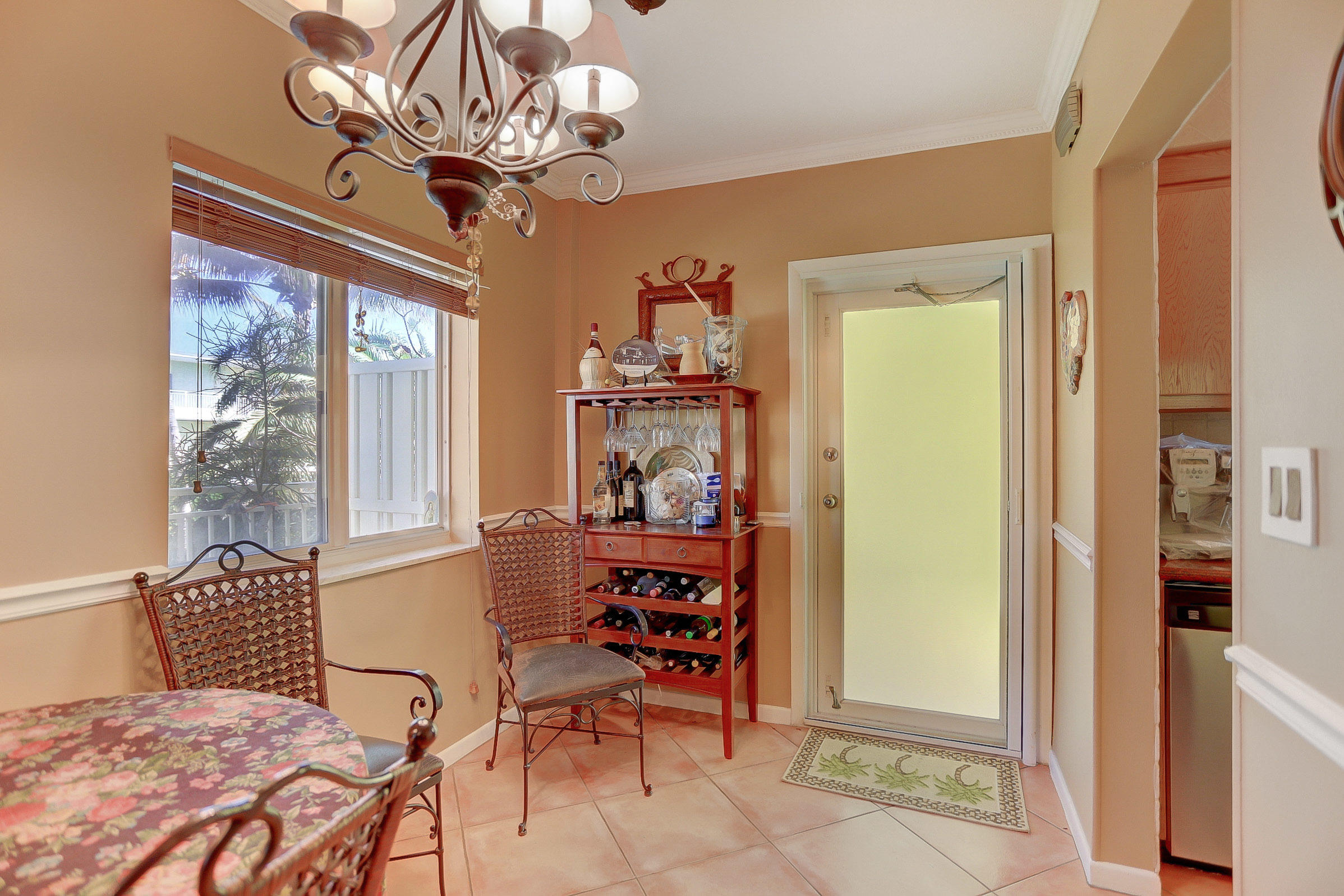 6520 North Ocean Boulevard, Unit 28 Ocean Ridge, FL 33435 - Photo 5 of 32 a bedroom with a bed and a chandelier