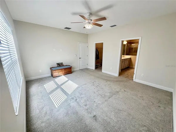 an empty room with closet and ceiling fan