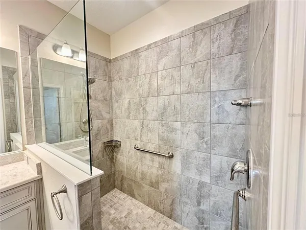 a bathroom with a sink a vanity and shower