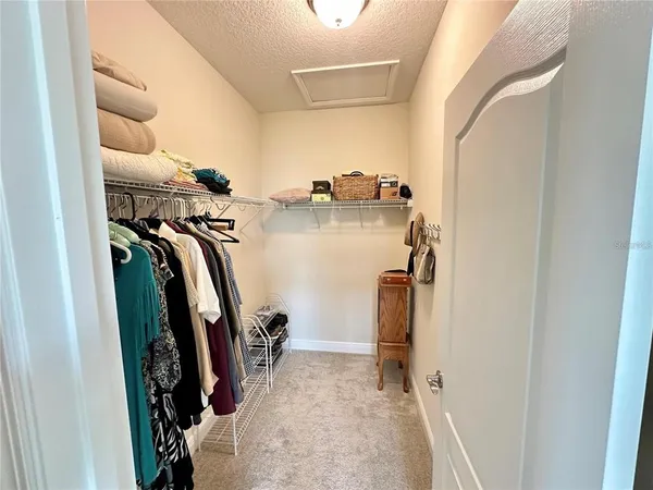 a view of walk in closet with clothes and shoes