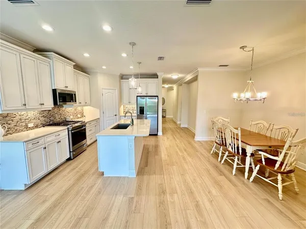 a large kitchen with granite countertop lots of counter top space and stainless steel appliances