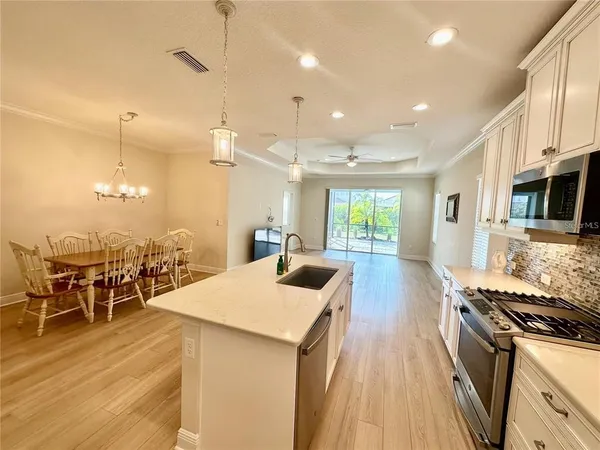 a large kitchen with lots of counter space a sink appliances and a dining table