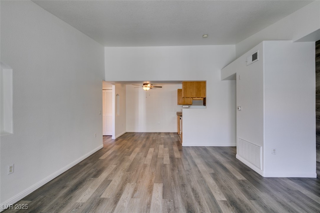 3318 North Decatur Boulevard, Unit 2138 Las Vegas, NV 89130 - Photo 16 of 40 Unfurnished living room with wood finished floors, a ceiling fan, and baseboards
