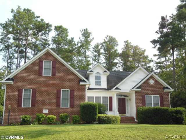 a front view of a house with yard and green space