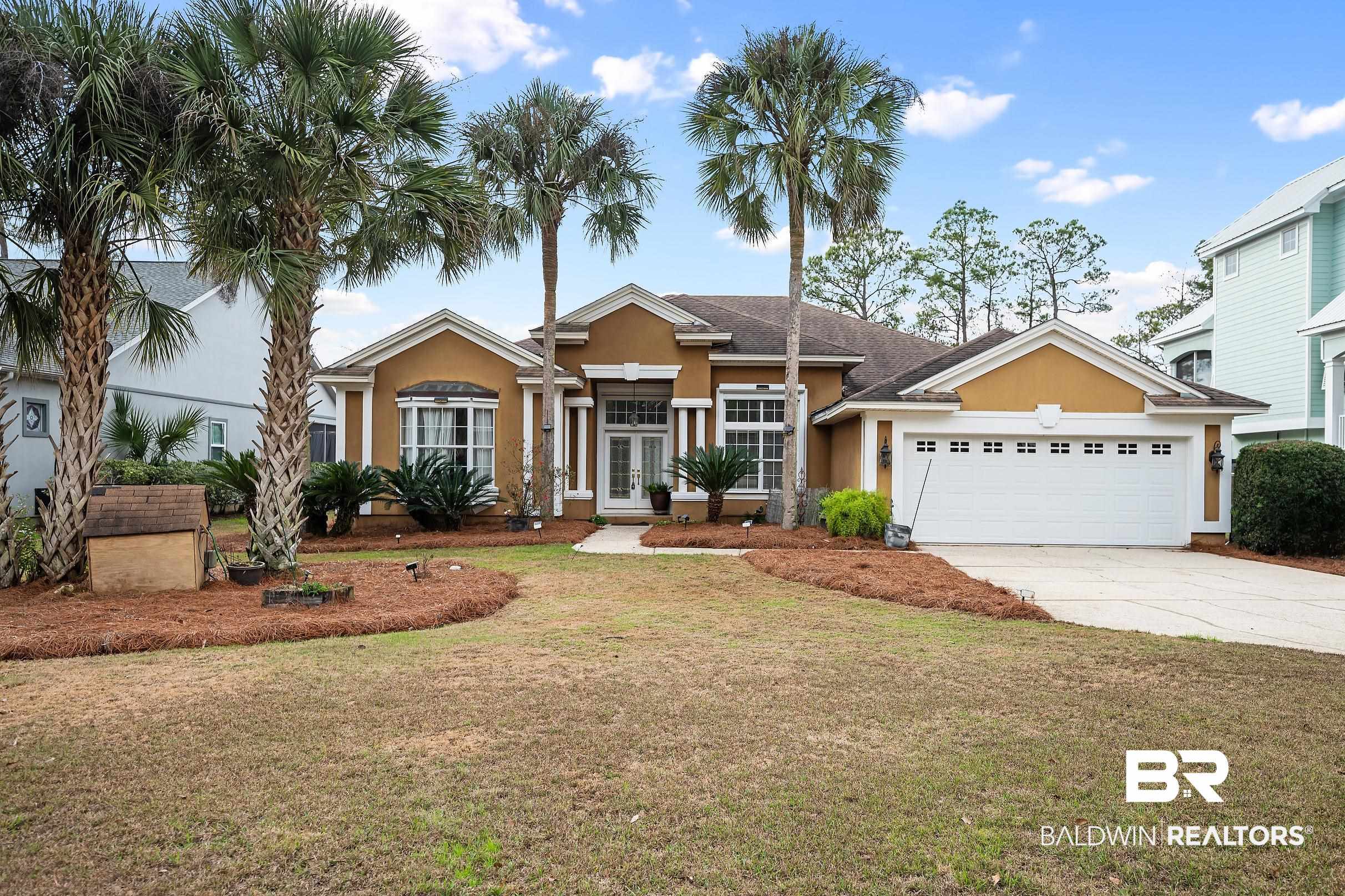 8591 Bay Harbor Road Elberta, AL 36530 - Photo 3 of 56 View of front of house with a front lawn, stucco siding, concrete driveway, french doors, and a garage