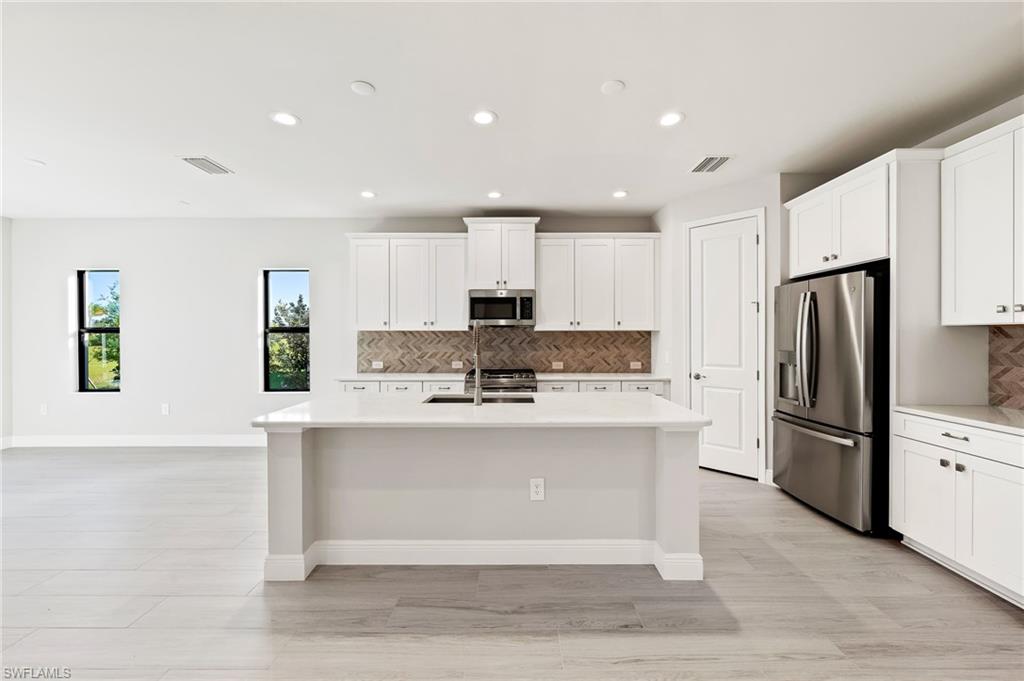 3952 Pegasus Way Naples, FL 34120 - Photo 11 of 50 a large kitchen with stainless steel appliances a refrigerator stove microwave and cabinets