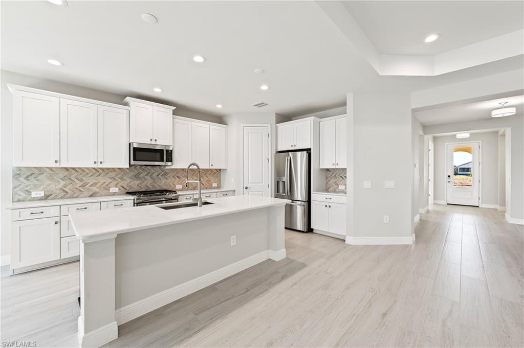 3952 Pegasus Way Naples, FL 34120 - Photo 13 of 50 a kitchen with stainless steel appliances a refrigerator sink and cabinets