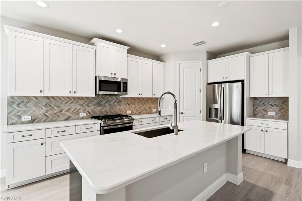 3952 Pegasus Way Naples, FL 34120 - Photo 15 of 50 a kitchen with stainless steel appliances a stove microwave and refrigerator