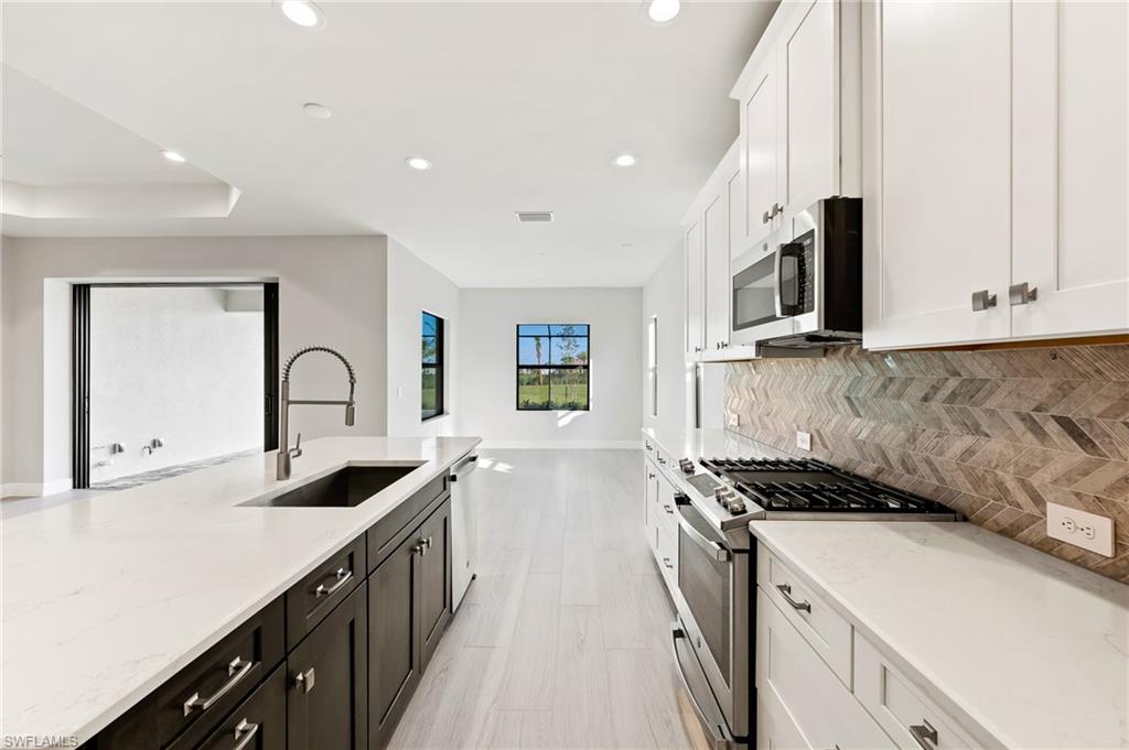 3952 Pegasus Way Naples, FL 34120 - Photo 18 of 50 a kitchen with granite countertop a sink and cabinets