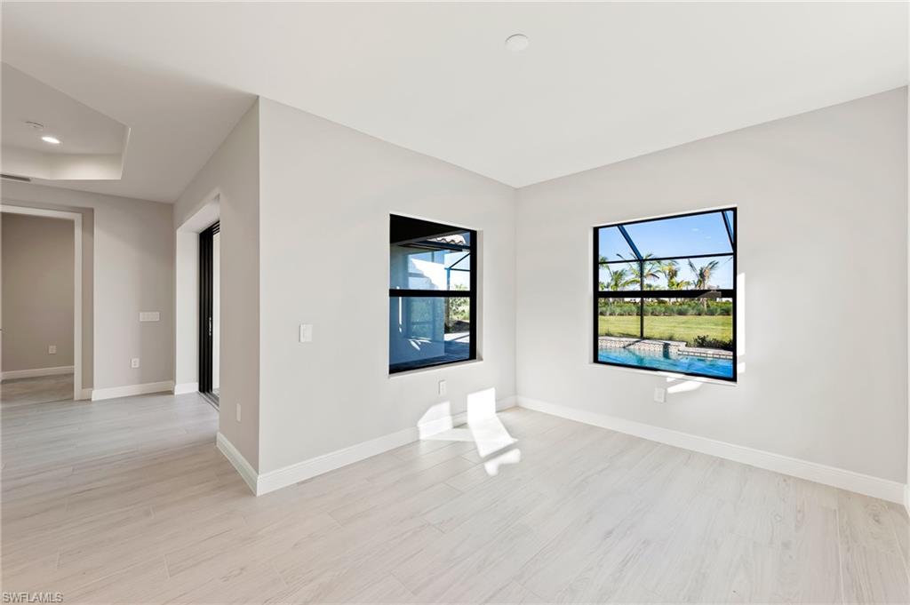 3952 Pegasus Way Naples, FL 34120 - Photo 19 of 50 a view of an empty room with window and wooden floor
