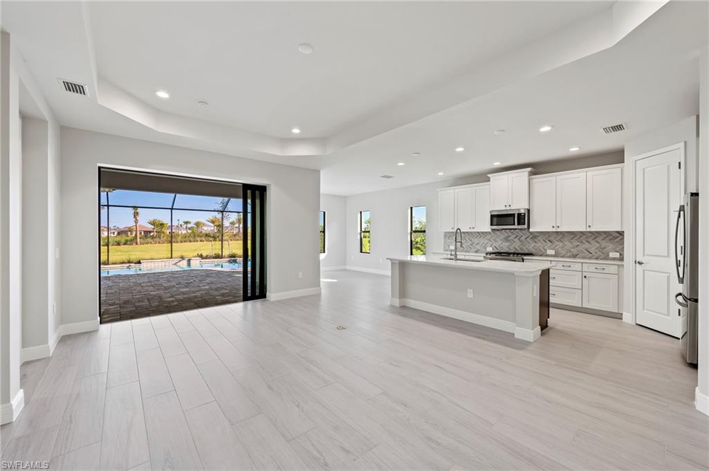 3952 Pegasus Way Naples, FL 34120 - Photo 4 of 50 a open kitchen with white cabinets and stainless steel appliances