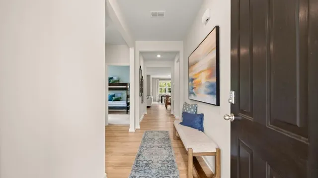 a hallway with a large mirror and vanity