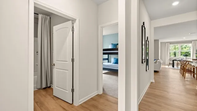 a view of a hallway with wooden floor and living room