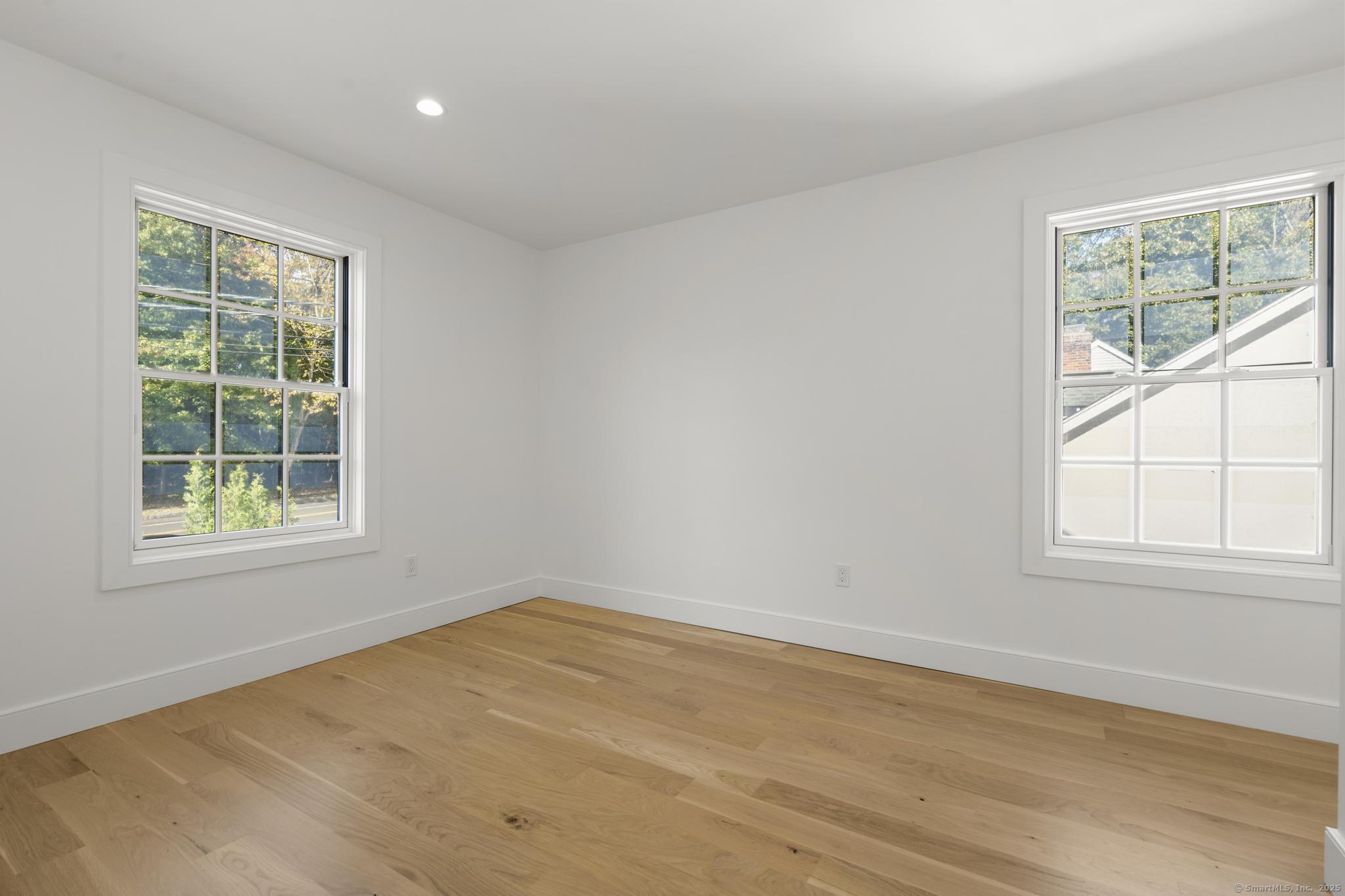 18 Sound Beach Avenue Greenwich, CT 06870 - Photo 11 of 36 an empty room with wooden floor and windows